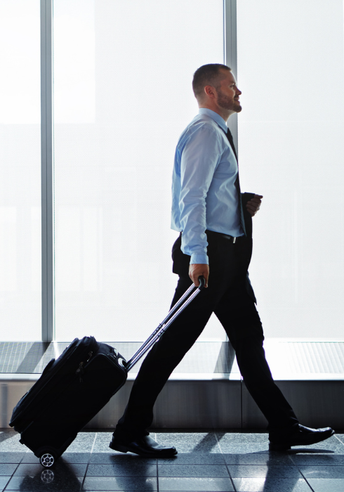 Two corporate travellers walking with luggage at an airport