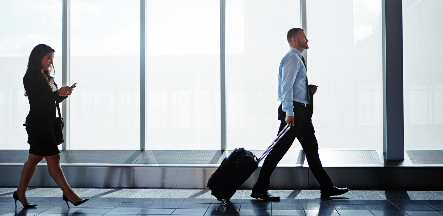 Two corporate travellers walking with luggage at an airport